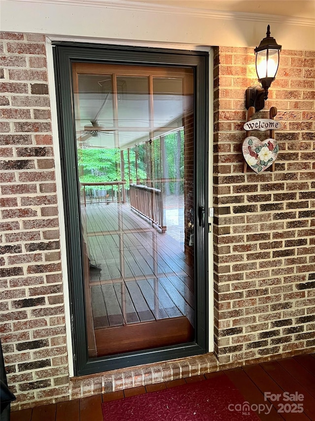 entrance to property featuring brick siding