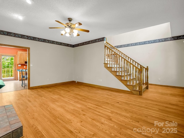 163 Summit Ln, Rutherfordton, NC 28139 - unfurnished living room with stairs, ceiling fan, baseboards, and light wood-type flooring
