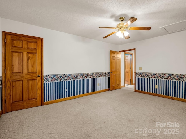 163 Summit Ln, Rutherfordton, NC 28139 - spare room with a textured ceiling, carpet floors, a ceiling fan, wainscoting, and wallpapered walls