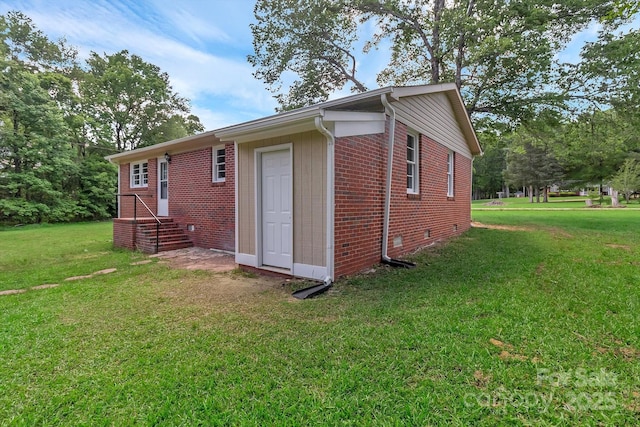 view of property exterior featuring brick siding, crawl space, and a yard
