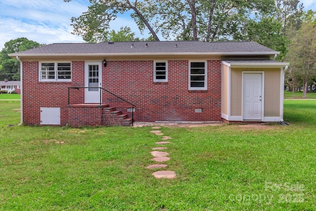 rear view of house with a yard, brick siding, and crawl space