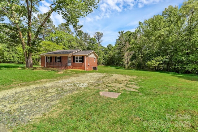 view of grassy yard with covered porch and central AC unit