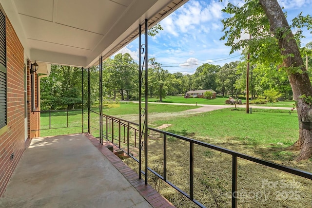 view of patio featuring covered porch and view of wooded area