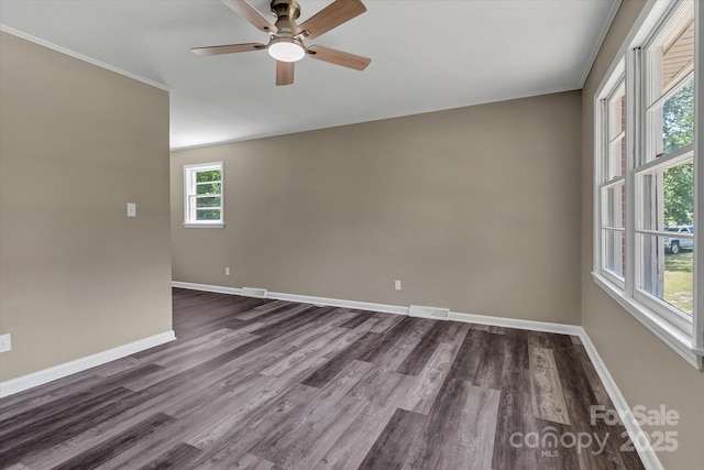 empty room featuring ceiling fan, baseboards, dark wood-style flooring, and ornamental molding