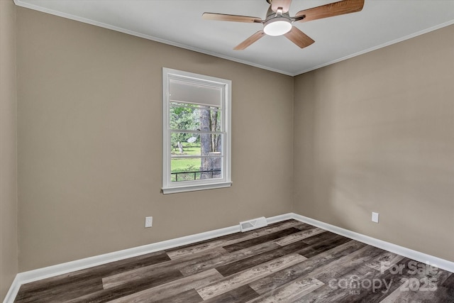 empty room with dark wood finished floors, ornamental molding, baseboards, and a ceiling fan