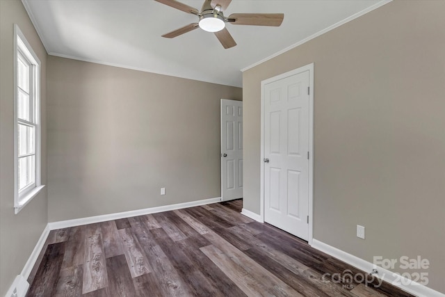 spare room with ceiling fan, plenty of natural light, baseboards, dark wood-style floors, and crown molding