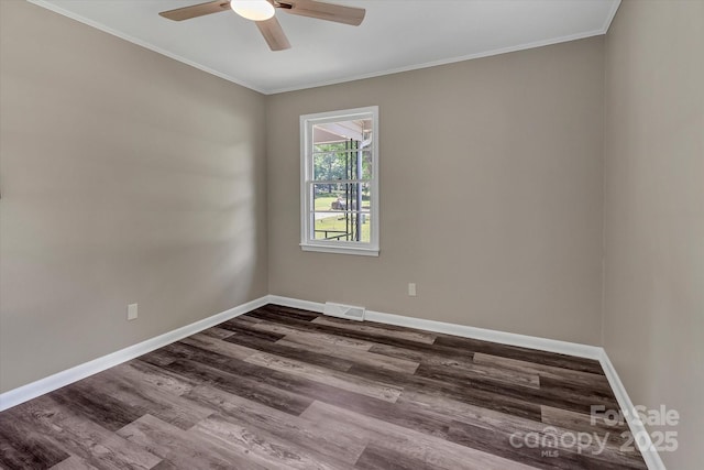 unfurnished room featuring ceiling fan, dark wood-type flooring, baseboards, and crown molding