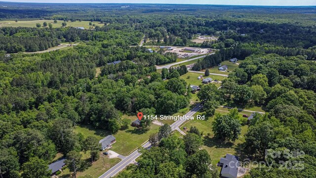 aerial view of property and surrounding area with a forest