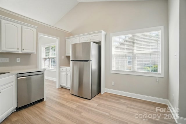 8309 Emily Dr, Harrisburg, NC 28075 - kitchen with appliances with stainless steel finishes, white cabinets, light countertops, light wood-style flooring, and lofted ceiling