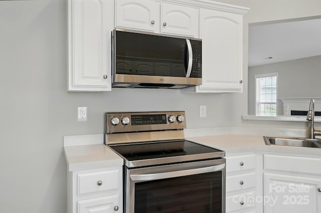 8309 Emily Dr, Harrisburg, NC 28075 - kitchen featuring electric stove, a sink, white cabinets, and light countertops