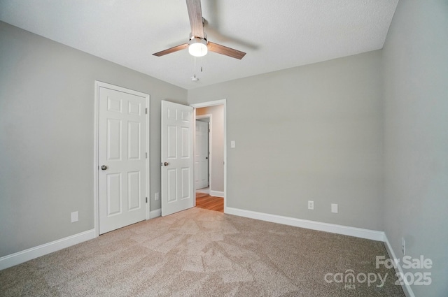 unfurnished bedroom featuring carpet, baseboards, and a ceiling fan