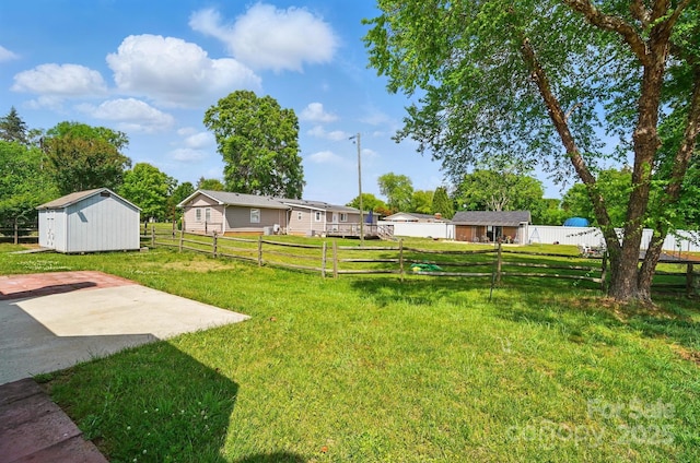 view of yard with a patio, an outbuilding, and a shed