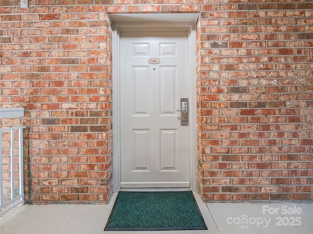 doorway to property featuring brick siding