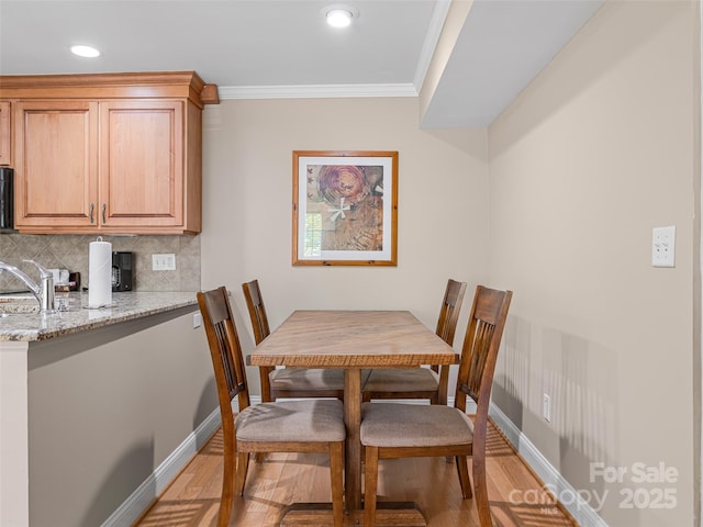 dining area featuring light wood-type flooring, baseboards, ornamental molding, and recessed lighting