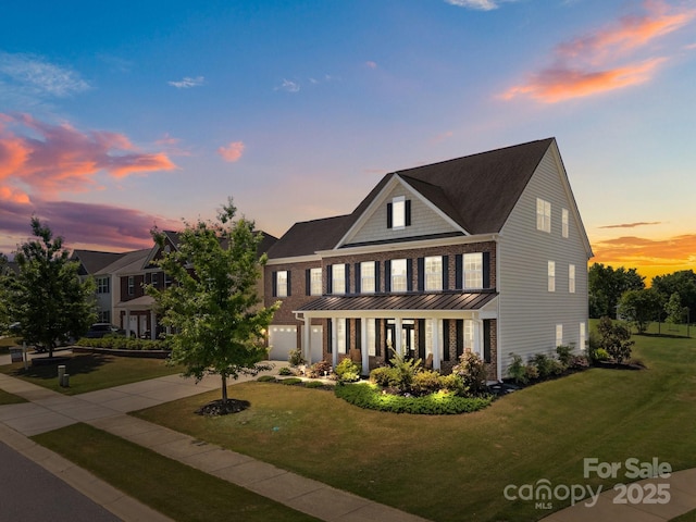 9871 Travertine Trl, Davidson, NC 28036 - view of front of property featuring brick siding, a yard, driveway, and a standing seam roof