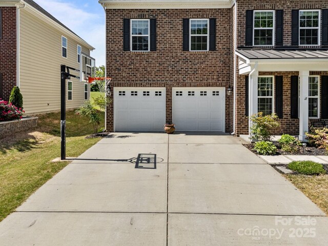 9871 Travertine Trl, Davidson, NC 28036 - view of front of house with brick siding, concrete driveway, a garage, a standing seam roof, and a front yard