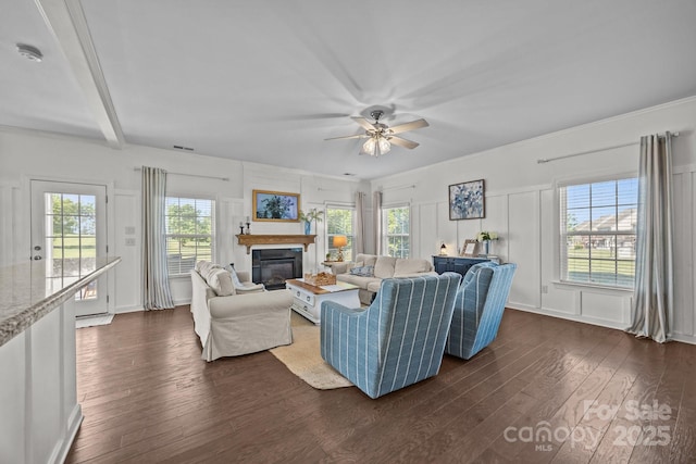 9871 Travertine Trl, Davidson, NC 28036 - living area featuring dark wood-type flooring, a glass covered fireplace, a decorative wall, a ceiling fan, and plenty of natural light