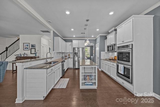 9871 Travertine Trl, Davidson, NC 28036 - kitchen featuring appliances with stainless steel finishes, a sink, a peninsula, dark stone countertops, and open shelves