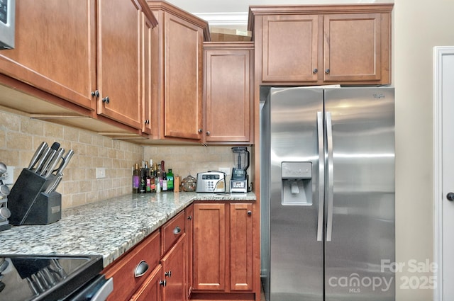 14837 Dungannon Ct, Charlotte, NC 28278 - kitchen with stainless steel fridge, decorative backsplash, light stone countertops, and brown cabinets