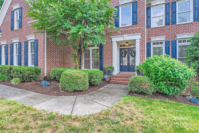 doorway to property featuring french doors and brick siding