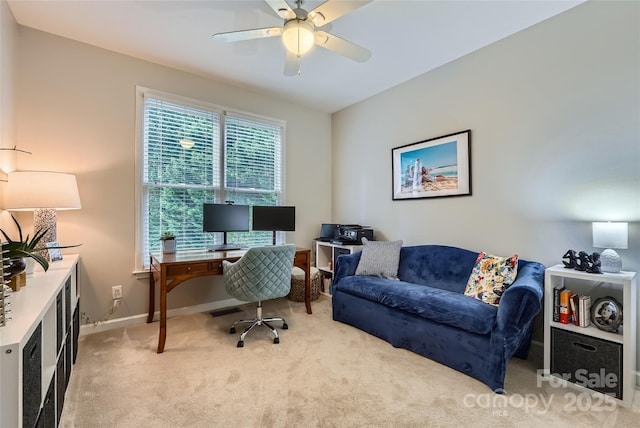 office space featuring light colored carpet, baseboards, and a ceiling fan