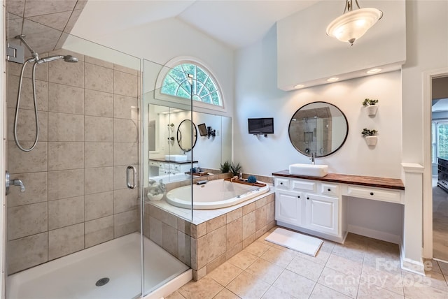 bathroom featuring a stall shower, tile patterned floors, vanity, a garden tub, and vaulted ceiling