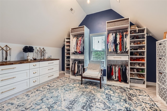 spacious closet featuring lofted ceiling, light wood-style floors, and visible vents