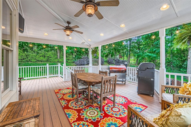 wooden deck featuring area for grilling, ceiling fan, and outdoor dining space