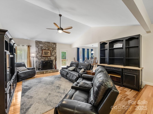 17501 Youngblood Rd, Charlotte, NC 28278 - living area featuring light wood-type flooring, a stone fireplace, ceiling fan, and vaulted ceiling