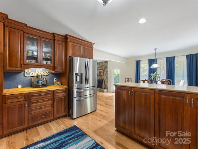 17501 Youngblood Rd, Charlotte, NC 28278 - kitchen with stainless steel refrigerator with ice dispenser, light wood-style flooring, glass insert cabinets, hanging light fixtures, and butcher block countertops