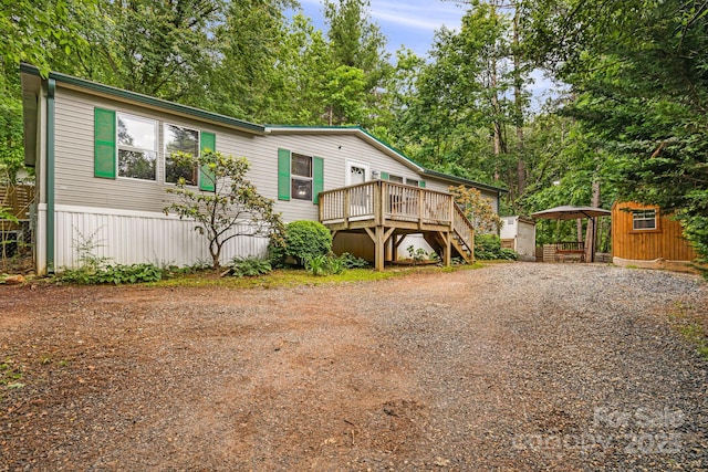 15 Robin Ln, Asheville, NC 28806 - manufactured / mobile home featuring a deck, stairs, driveway, a detached carport, and view of wooded area
