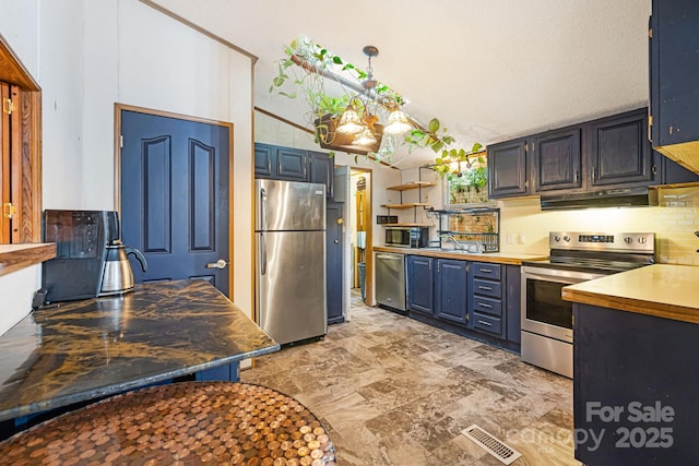 15 Robin Ln, Asheville, NC 28806 - kitchen with stainless steel appliances, under cabinet range hood, decorative backsplash, blue cabinetry, and open shelves