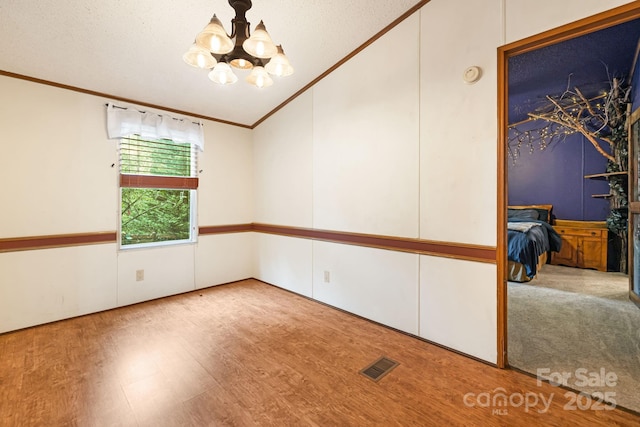 15 Robin Ln, Asheville, NC 28806 - empty room with crown molding, lofted ceiling, a chandelier, and wood finished floors