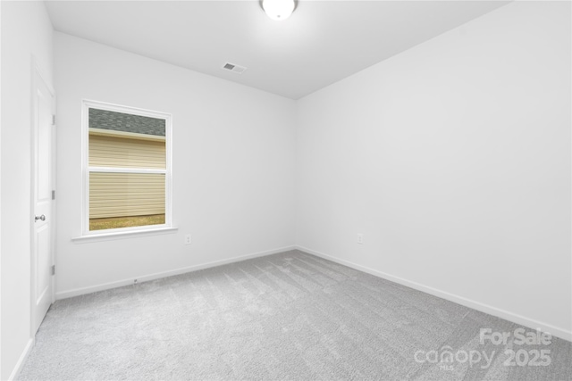 carpeted empty room featuring baseboards and visible vents