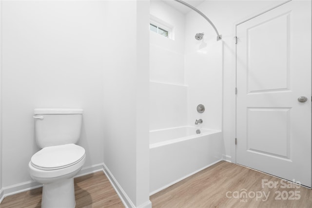 full bathroom featuring toilet, baseboards, tub / shower combination, and wood finished floors