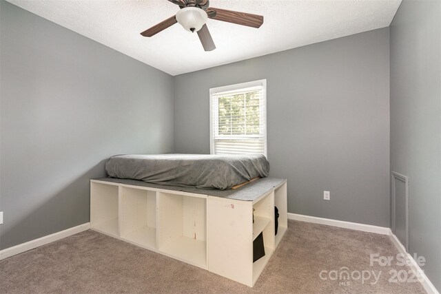 131 Scotland Dr, Mooresville, NC 28115 - bedroom featuring a textured ceiling, baseboards, ceiling fan, and carpet floors