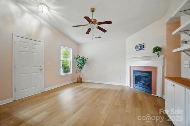 1162 Willet Dr, Rock Hill, SC 29732 - unfurnished living room with vaulted ceiling, a tile fireplace, a ceiling fan, light wood-style flooring, and baseboards