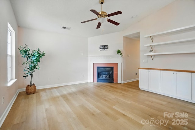 1162 Willet Dr, Rock Hill, SC 29732 - unfurnished living room with light wood-type flooring, a ceiling fan, a glass covered fireplace, plenty of natural light, and vaulted ceiling