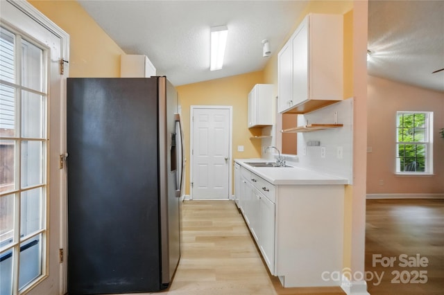 1162 Willet Dr, Rock Hill, SC 29732 - kitchen featuring stainless steel fridge, vaulted ceiling, a sink, light wood-type flooring, and white cabinets