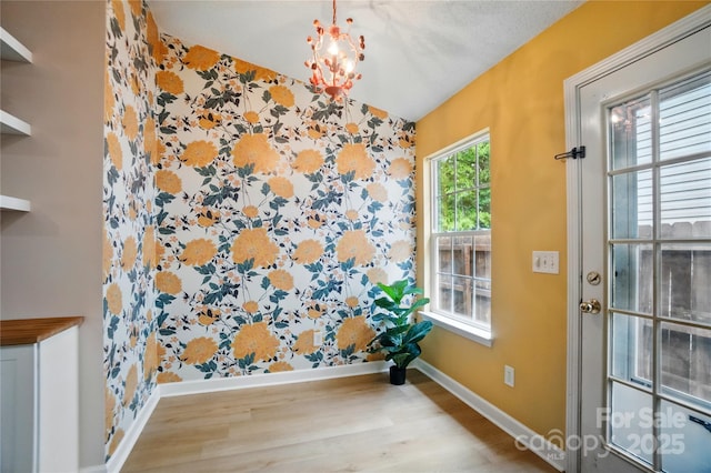 1162 Willet Dr, Rock Hill, SC 29732 - unfurnished dining area featuring wallpapered walls, baseboards, wood finished floors, an accent wall, and a chandelier