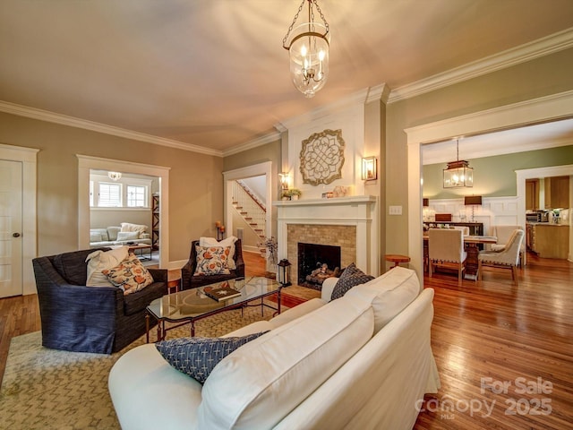 226 Union St S, Concord, NC 28025 - living room with a chandelier, crown molding, wood finished floors, and a brick fireplace