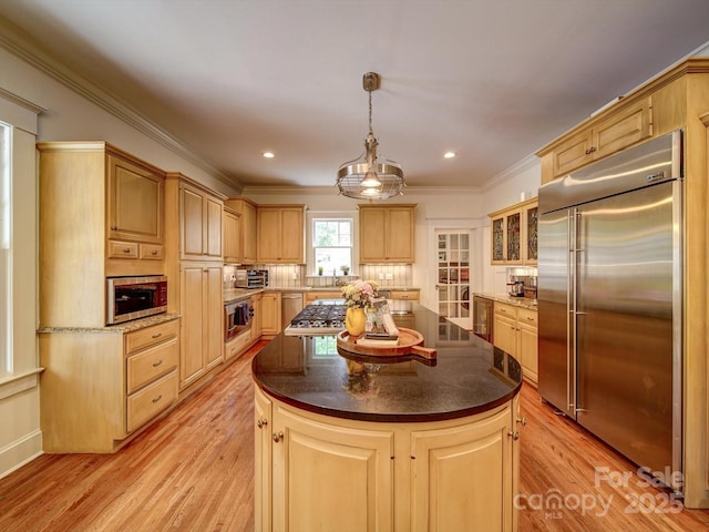 226 Union St S, Concord, NC 28025 - kitchen with appliances with stainless steel finishes, light brown cabinetry, light wood finished floors, a kitchen island, and crown molding