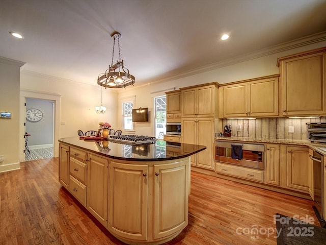 226 Union St S, Concord, NC 28025 - kitchen with a center island, stainless steel appliances, ornamental molding, light wood-style floors, and decorative light fixtures