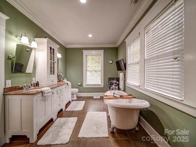 226 Union St S, Concord, NC 28025 - bathroom featuring baseboards, ornamental molding, a freestanding bath, vanity, and toilet