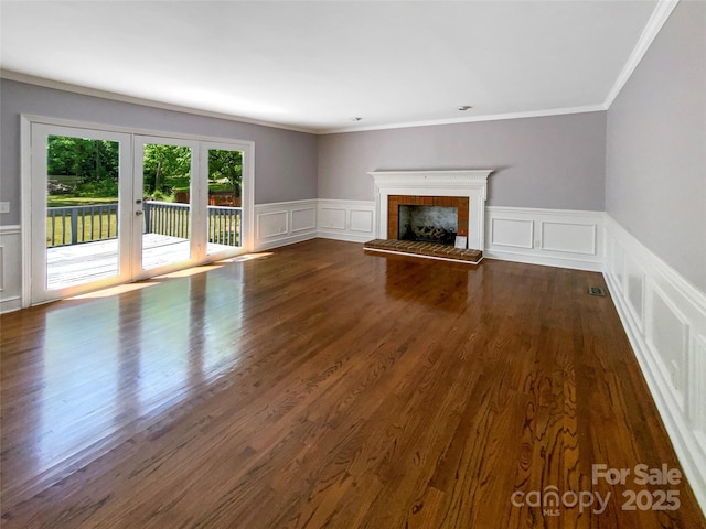 unfurnished living room featuring ornamental molding, a decorative wall, french doors, and a tile fireplace