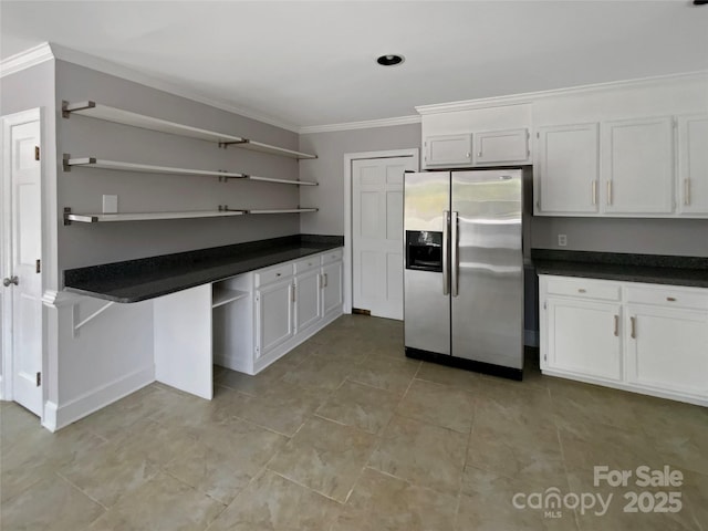 kitchen featuring open shelves, crown molding, stainless steel fridge, and dark countertops