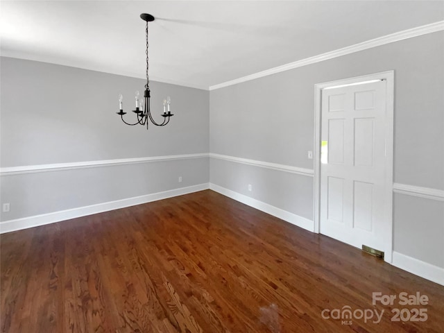 unfurnished dining area featuring baseboards, ornamental molding, an inviting chandelier, and dark wood-style floors