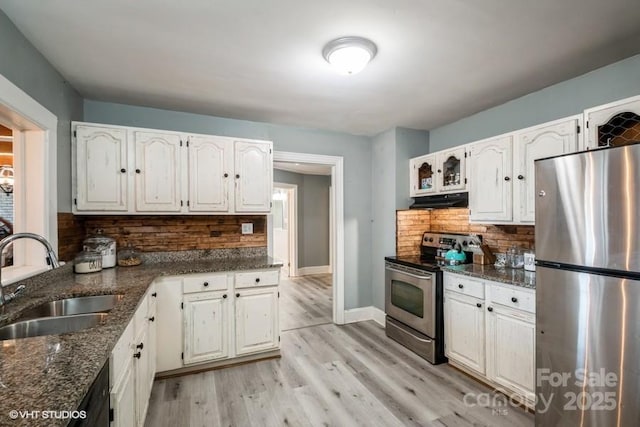 kitchen featuring white cabinets, decorative backsplash, stainless steel appliances, and a sink