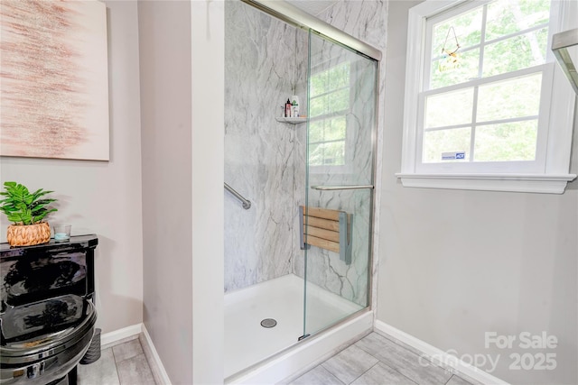 full bath with baseboards and a marble finish shower