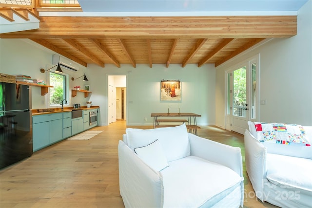 living area featuring wooden ceiling, beam ceiling, healthy amount of natural light, light wood finished floors, and an AC wall unit